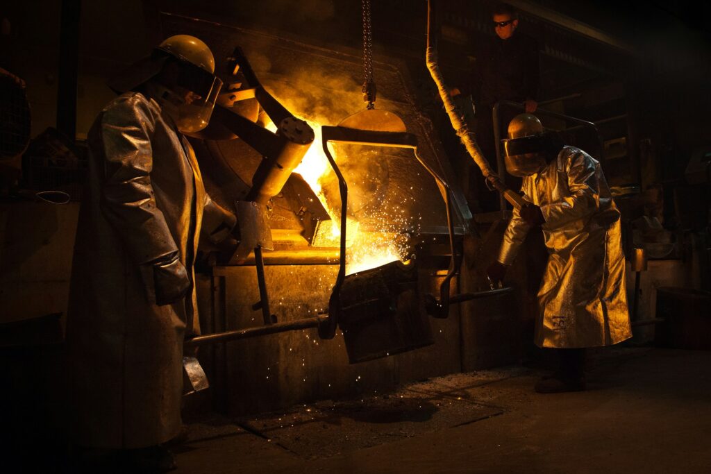 Foundry crew handling a ladle of molten metal